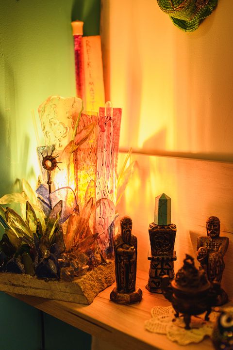 A shelf with figures and crystals in warm lamplight